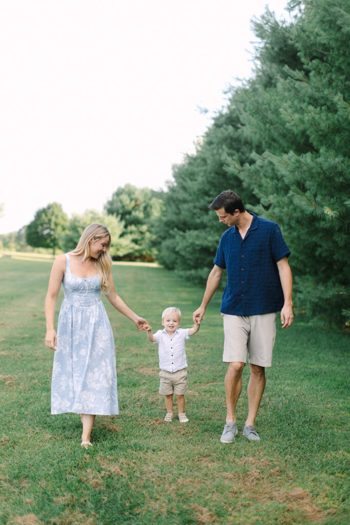 Parents and child walking together during a relaxed outdoor spring family photography session in Michigan.