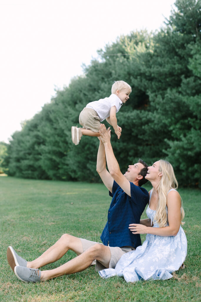 Mother and father holding their children during a natural outdoor family portrait session in Lansing, Michigan.