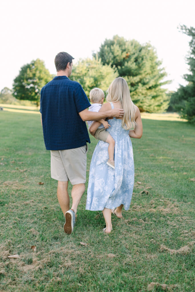 Mother and father holding their child during a natural outdoor family portrait session in Lansing, Michigan.