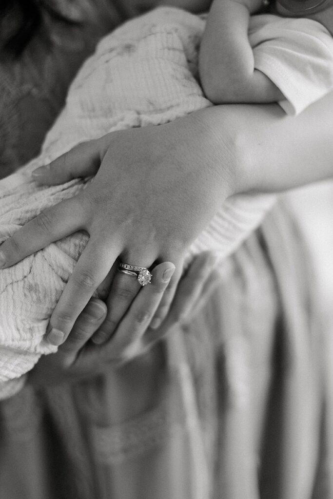 Mother holding her newborn baby in the nursery during a cozy in-home newborn photography session in Michigan.