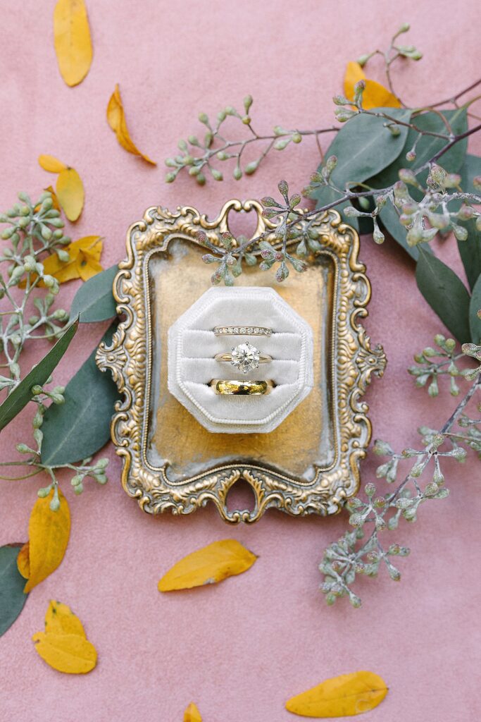 bride and grooms rings on display on a vintage tray