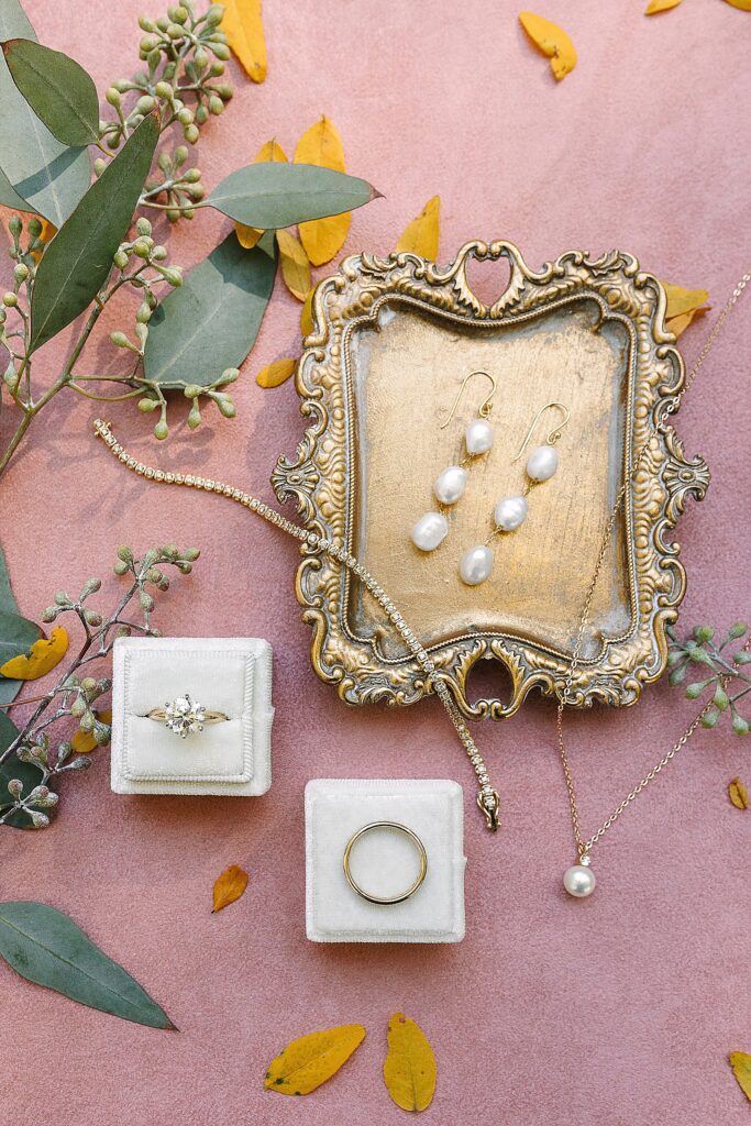 brides jewelry laid out on a vintage tray