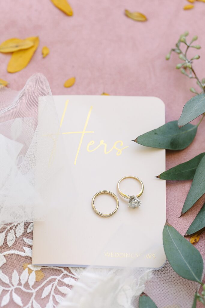 brides vow book with her engagement ring and wedding band