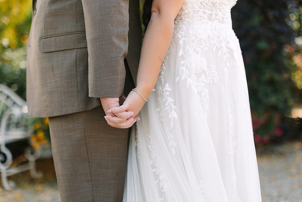 bride and groom opt for a first touch instead of a first look and are holding hands while standing back to back