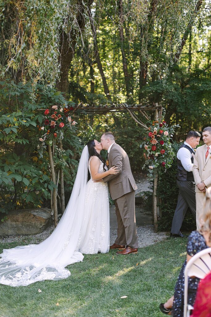 bride and grooms first kiss at everlastings in the wildwood wedding venue